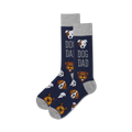 A pair of navy blue crew socks with a pattern of various dog breeds and the text 'Dog Dad'.  Grey cuffs.