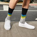 Lifestyle shot of a man wearing the chevron socks with white slip on shoes. [lf]