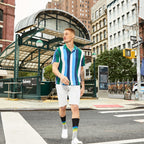 Lifestyle shot of a man wearing one of the striped socks with white sneakers; city background. [lf]