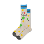 A close-up studio shot shows a pair of beige pickleball socks with teal stripes. The design includes paddles, balls, and the text 'I love Pickleball'.