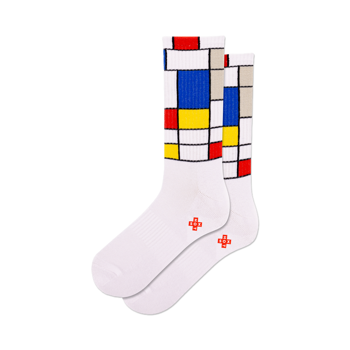 front view of a pair of white socks with a mondrian-inspired design in red, yellow, and blue.