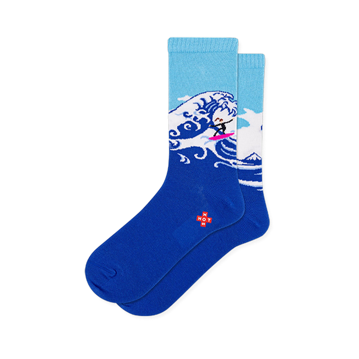 Light and dark blue crew socks showing a large Japanese-style crashing wave with a tiny surfer on a bright pink surfboard. }}