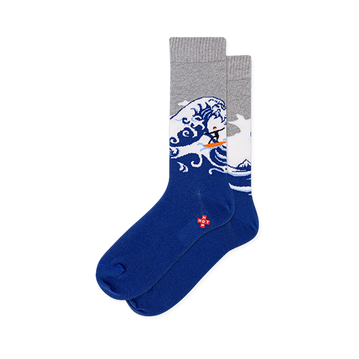 Crew socks with a solid dark blue foot, heather gray top, and a large crashing wave with a tiny surfer on an orange board. }}