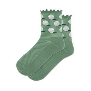 A pair of sage green crew socks with white dimpled golf balls and small green grass patches on the ankle, ribbed lower.