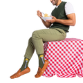 Man in olive green pants and sweater vest, sitting and eating spaghetti, wearing olive green socks with a fork design.