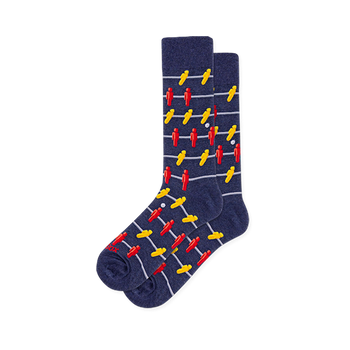 Dark blue crew socks covered in a pattern of red and yellow foosball players on horizontal grey bars with a white ball.