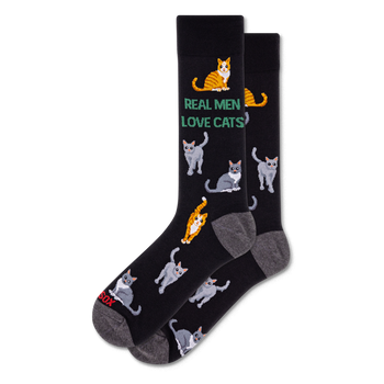 Pair of black crew socks with grey heel and toe. Features green text 'REAL MEN LOVE CATS' and an all-over pattern of grey and orange tabby cats.