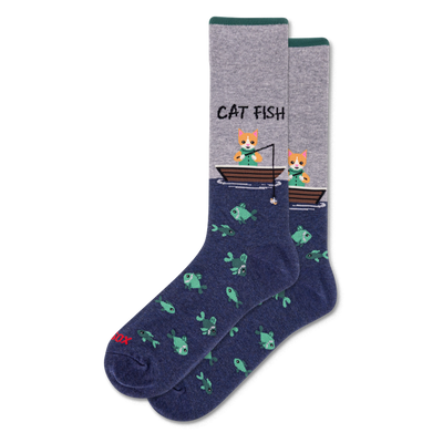 Crew socks with heather grey top, dark green cuff, and navy blue bottom. Design shows "CAT FISH" text, cats fishing from boats, and a pattern of green fish.