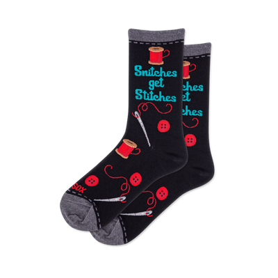 Pair of black crew socks featuring 'Snitches get Stitches' text, red thread spools, buttons, and white sewing needles.
