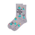 Pair of grey crew socks with a repeating pattern of cartoon dogs in teal medical scrubs, some with stethoscopes. Text reads "TRUST ME I'M A DOGTOR".
