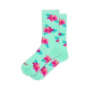 Mint green crew socks covered in a scattered pattern of bright pink hibiscus flowers with yellow centers and teal leaves.