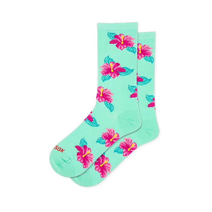 Mint green crew socks covered in a scattered pattern of bright pink hibiscus flowers with yellow centers and teal leaves.