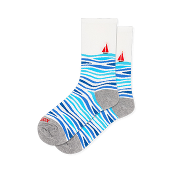 White crew socks featuring wavy light and dark blue stripes on the foot and a red sailboat on the calf, with a grey heel.