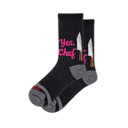 Black crew socks featuring bright pink Yes Chef text next to a silver chef knife graphic, complete with grey heels and toes.