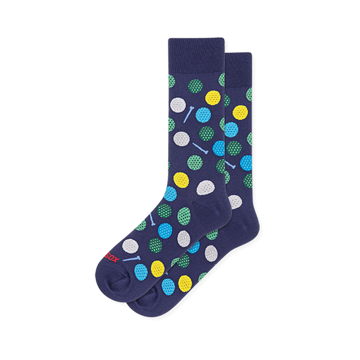Navy blue crew socks covered in dimpled golf balls in white, yellow, green and blue, with small light blue golf tees.