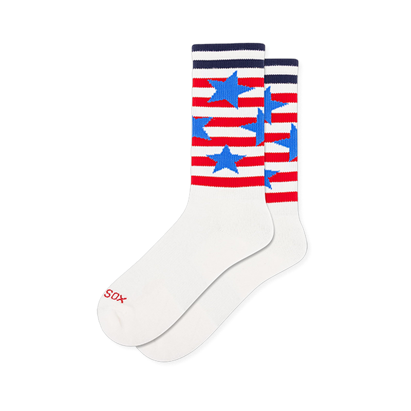 Athletic white crew socks with a ribbed leg. The upper features red and white horizontal stripes scattered with blue stars.