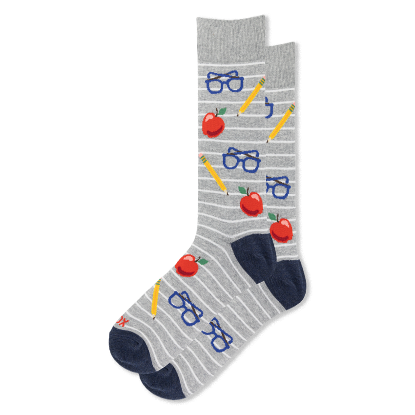 Grey crew socks with white stripes featuring a pattern of red apples, yellow pencils, and blue eyeglasses with navy heels.