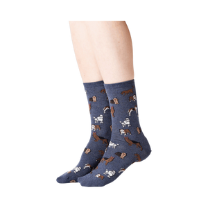 Lifestyle shot of woman's legs wearing navy blue crew socks with dogs on them.