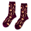 Burgundy crew socks showing a pattern of golden chains, curved daggers, and flaming hearts with an eye in the center.