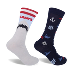 Two crew socks. One gray with red/white stripes and a Jaws shark graphic; one navy blue with nautical anchors, wheels, and small shark graphics.