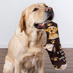 Lifestyle product shot: A yellow lab gently holds one of the 'I Love My Yellow Lab' socks in its mouth.