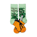 A pair of crew socks. One sock is mint green with a basil plant illustration, the other is orange with a gardening pot design. Both socks say 'These are my gardening socks'.