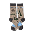 Pair of crew hiking socks. Tan background with a trail, trees, mountains, and a small hiker graphic.  Grey cuffs and light blue water detail.
