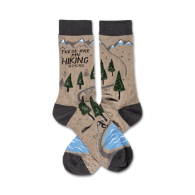 brown crew socks with hiking trail graphic including mountains, trees, river and hiker. text 'these are my hiking socks' displayed on top of socks. for men and women.  