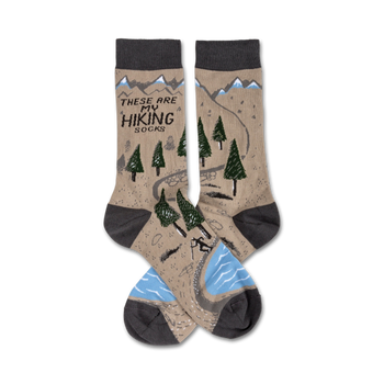 brown crew socks with hiking trail graphic including mountains, trees, river and hiker. text 'these are my hiking socks' displayed on top of socks. for men and women.  