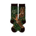 A pair of crew socks with sloths hanging from tree branches on a green background.  The socks are brown and green, and feature the text 'Don't Rush Me'.