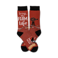 A pair of crew socks in red and black features a barn, windmill, chicken, and cow. The text 'Living the Farm Life' is prominently displayed.
