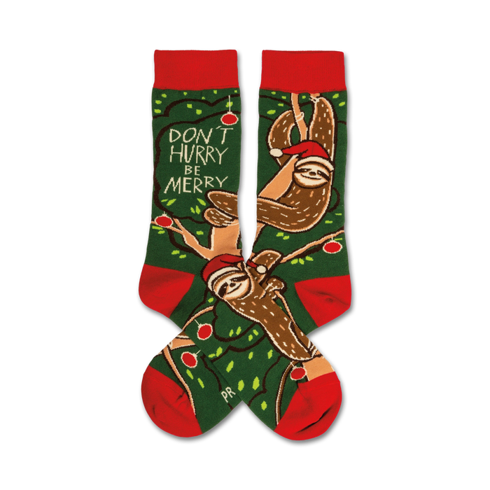 green christmas crew socks with red cuffs and toes. brown sloths wear red santa hats and hang from a branch with green leaves and red ornaments. text on the sock toes says 'don't hurry be merry'.   }}
