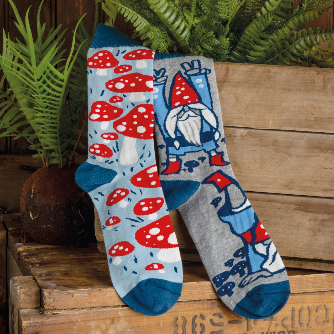 Lifestyle shot of Gnomes & Mushrooms socks on a wooden surface with plants. [lf]