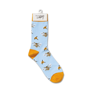 A pair of blue socks with a pattern of yellow bees and white and yellow flowers. The socks have a yellow toe and heel.