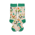 Cream crew socks with green cuffs, featuring a whimsical garden design of gnomes, flowers, mushrooms, and gardening tools.