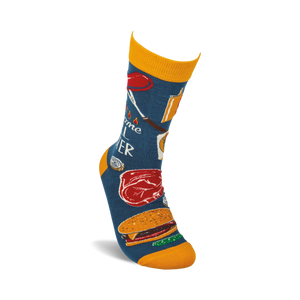 A pair of blue socks with a pattern of grilling items, including a hot dog, a steak, a hamburger, and a grill fork. The socks are labeled 