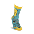 Lifestyle shot of a person's foot wearing one of the teal and yellow 'Working From Home' socks.