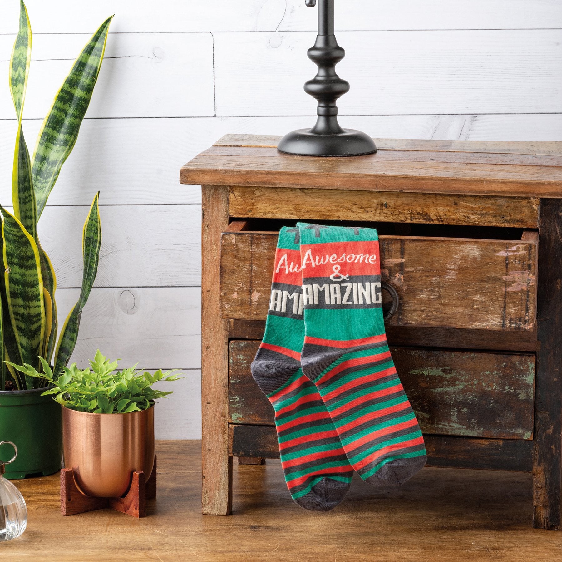 Lifestyle shot of Awesome & Amazing socks peeking from a dresser drawer, showcasing the socks in a real-life setting. [lf]