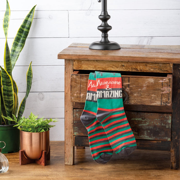 A pair of green socks with red and brown stripes and the words 