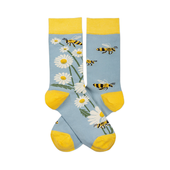 Pair of light blue crew socks with yellow cuffs, heels, toes. One sock has white daisies, the other has yellow and black bees.