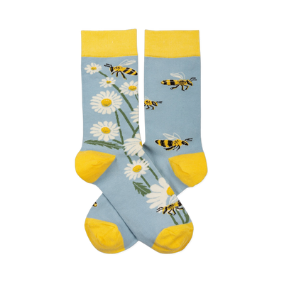 Pair of light blue crew socks with yellow cuffs, heels, toes. One sock has white daisies, the other has yellow and black bees.