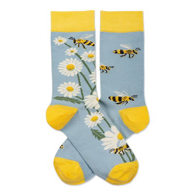 Pair of light blue crew socks with yellow cuffs, heels, toes. One sock has white daisies, the other has yellow and black bees.