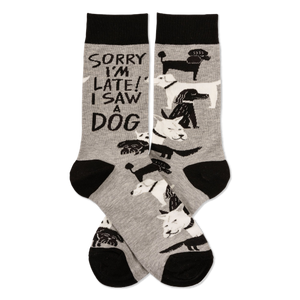 Pair of grey crew socks with black cuffs, heels, and toes, featuring white and black dogs and 