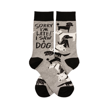 Pair of grey crew socks with black cuffs, heels, and toes, featuring white and black dogs and "SORRY I'M LATE! I SAW A DOG" text.