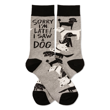 Pair of grey crew socks with black cuffs, heels, and toes, featuring white and black dogs and "SORRY I'M LATE! I SAW A DOG" text.