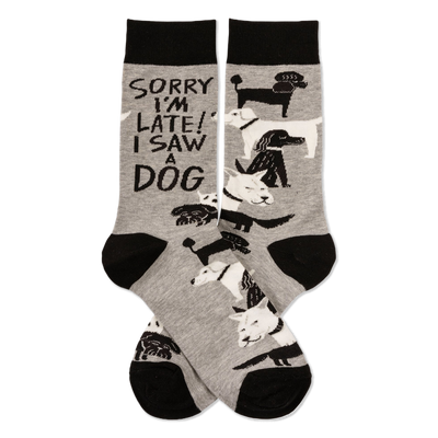 Pair of grey crew socks with black cuffs, heels, and toes, featuring white and black dogs and "SORRY I'M LATE! I SAW A DOG" text.