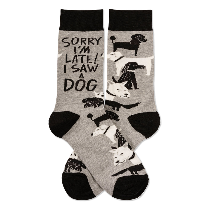 Pair of grey crew socks with black cuffs, heels, and toes, featuring white and black dogs and 