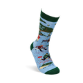 Single light blue crew sock with dark green trim. Design shows camping scenes, trees, a person chopping wood, and partial text 'R BE ING'.