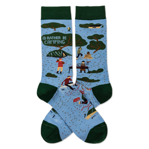 Pair of light blue crew socks with dark green trim. Features 'I'D RATHER BE CAMPING' text, trees, tents, and campers.
