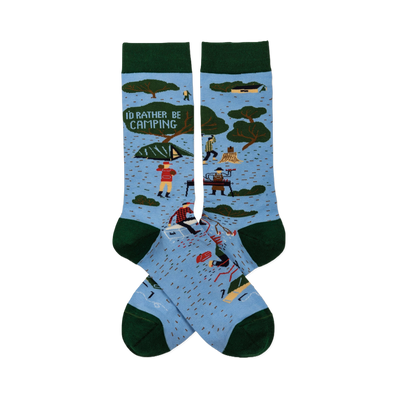 Pair of light blue crew socks with dark green trim. Features 'I'D RATHER BE CAMPING' text, trees, tents, and campers.